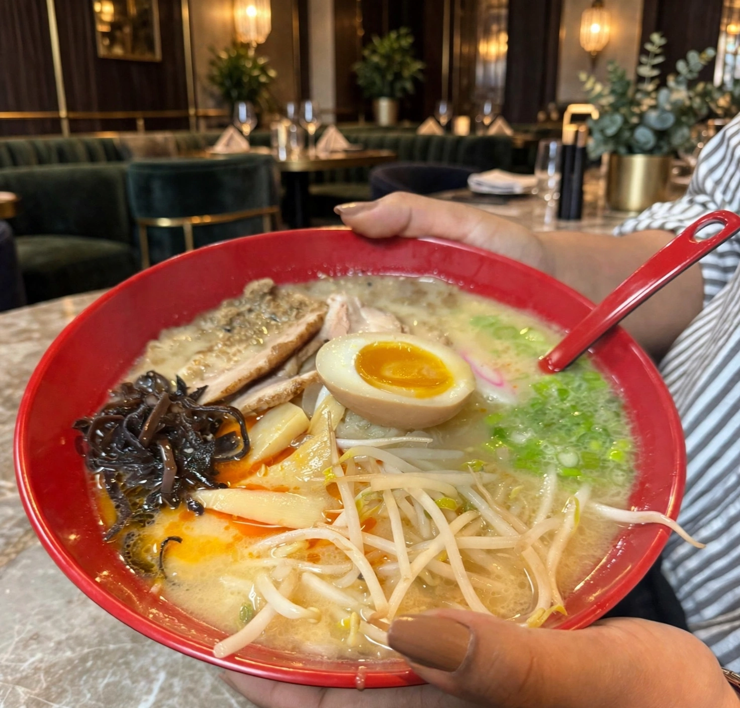 Steaming ramen bowl with chopsticks lifting noodles